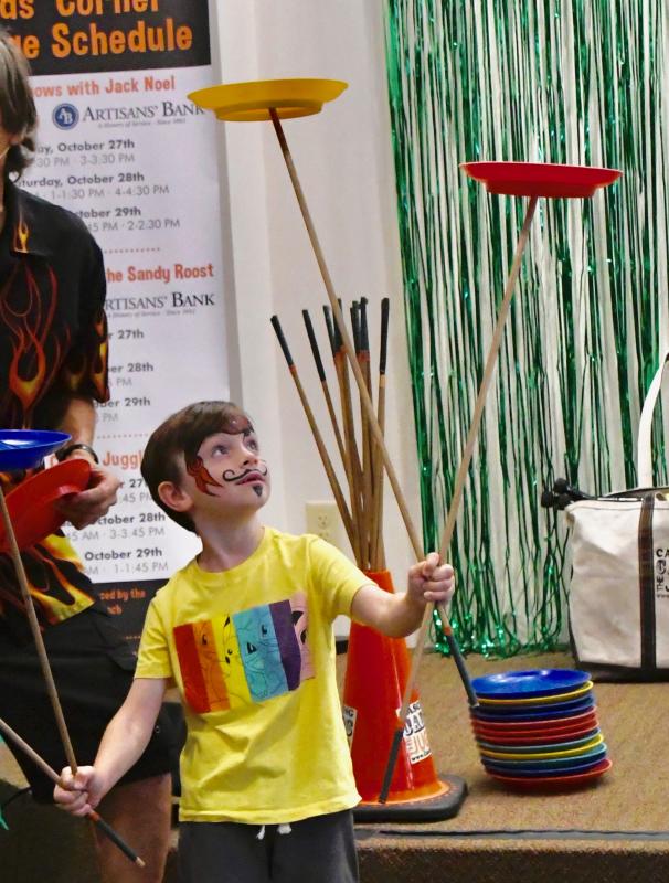 He’s a quick learner. Tadhg O’Dwyer of West Chester, Pa., keeps plates in the air with help from Cascading Carlos Mir the juggler. RON MACARTHUR PHOTO